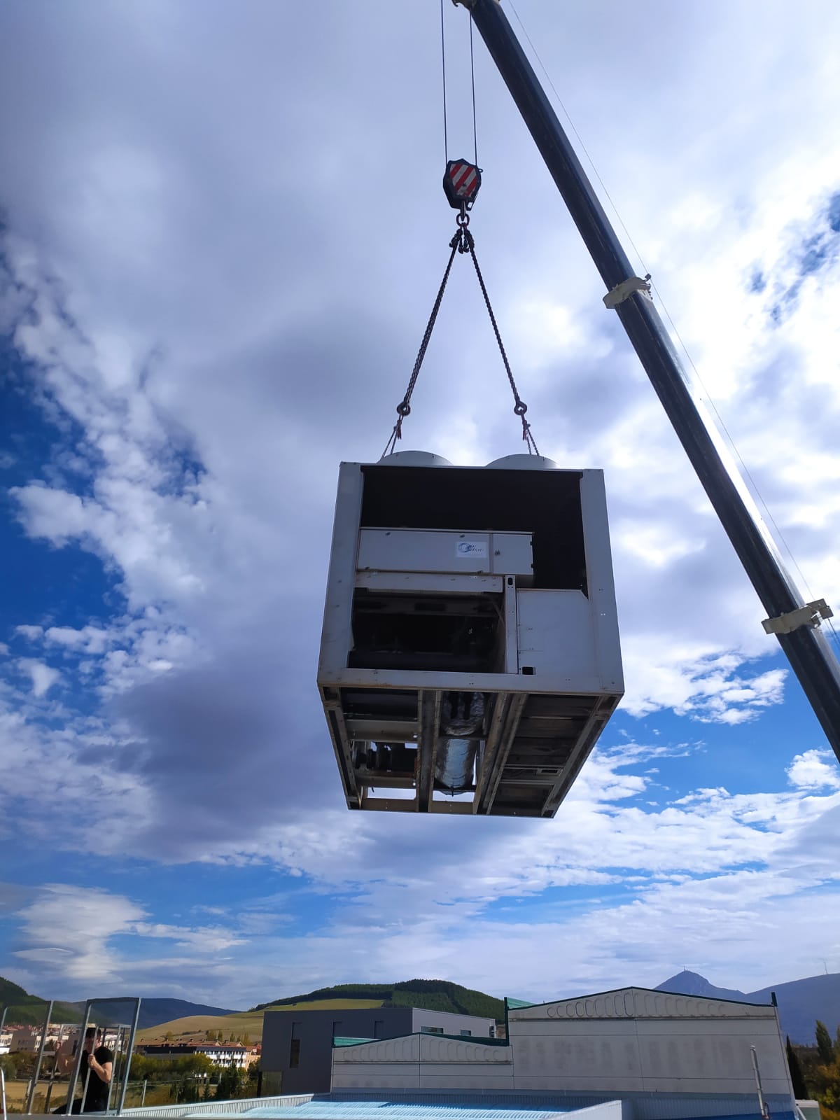 Grúa de gran tonelaje realizando la descarga e instalación urgente de una enfriadora de agua industrial de alquiler de la flota de CLIVI en una planta de producción.